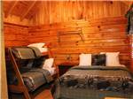 Main bed and bunk beds inside cabin at MILL CREEK RV PARK & VACATION RENTALS - thumbnail