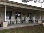 A row of white rocking chairs at PEACH COUNTRY RV PARK - thumbnail