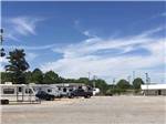Wide open gravel area with white and tan trailers parked alongside at LINCOLN CIVIC CENTER RV PARK - thumbnail