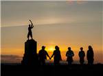 People standing by a statue at sunset at DESTINATION GETTYSBURG - thumbnail