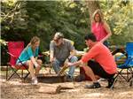 A family roasting hot dogs in a fire pit at DESTINATION GETTYSBURG - thumbnail