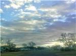 RVs in grassy campground under colorful sky at CLOVIS RV PARK - thumbnail