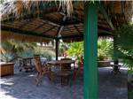Wooden table and chairs under canopy at SUN RESORTS RV PARK - thumbnail