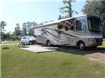 Motorhome with awning deployed on site with patio at LAKE JASPER RV VILLAGE - thumbnail