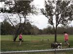 A girl and mom in the fenced in dog area at VICTORIA COLETO LAKE RV RESORT - thumbnail