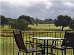 Table and chairs with golf course in background at ALSATIAN RV RESORT & GOLF CLUB - thumbnail
