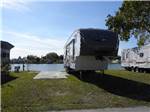 A firth wheel trailer in an RV site by the water at LAZY J RV & MOBILE HOME PARK - thumbnail