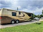 A large motorhome in a gravel RV site at GREEN ACRES RV PARK - thumbnail
