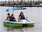A mother and her kids in a paddle boat at PALMETTO SHORES RV RESORT - thumbnail