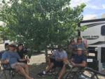 A group of people sitting outside of a trailer at NEW FRONTIER RV PARK - thumbnail