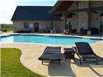 Swimming pool with outdoor seating at BY THE LAKE RV PARK - thumbnail