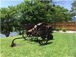 An old tractor in the grass at FLAT CREEK FARMS RV RESORT - thumbnail