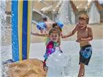 Young boy and girl playing in the splash park at CAPE CHARLES/CHESAPEAKE BAY KOA RESORT - thumbnail
