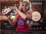 A woman in a cowboy hat mixing a drink at ROUTE 66 RV RESORT - thumbnail