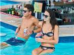 A couple enjoying drinks at the bar in the swimming pool at SUN OUTDOORS REHOBOTH BAY - thumbnail