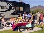 A group of people enjoying lunch and drinks by an motorhome at PALA CASINO RV RESORT - thumbnail