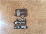 A Happy Campers Welcome sign at CRAZY HORSE RV RESORT - thumbnail