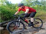 An man with a helmet mountain biking at THE COVE LAKESIDE RV RESORT AND CAMPGROUND - thumbnail