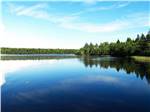 A view of the tree lined lake at CASTLE LAKE CAMPGROUND & COTTAGES - thumbnail