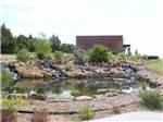 A waterfall and pond water feature at WANDERLUST CROSSINGS RV PARK - thumbnail
