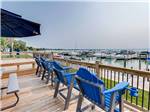 Blue chairs on a deck overlooking the marina at NORTHPOINTE SHORES RV RESORT - thumbnail