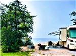 A motorhome parked by the water at MANISTIQUE LAKESHORE CAMPGROUND - thumbnail