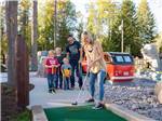 Family playing miniature golf at WEST GLACIER RV PARK & CABINS - thumbnail