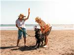 A couple playing with their dog on the beach at VISIT SLO CAL - SAN LUIS OBISPO COUNTY - thumbnail