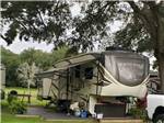 A fifth wheel parked in a gravel site at BREEZY OAKS RV PARK - thumbnail