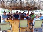 A group of people standing around the outdoor bar at SUNKISSED VILLAGE RV RESORT - thumbnail