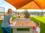 A family playing ping pong outdoors at LURAY RV RESORT & CAMPGROUND ON SHENANDOAH RIVER - thumbnail