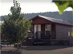 A wooden cabin with a deck at CASTLE GATE RV PARK & CAMPGROUND - thumbnail