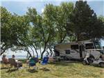 A couple sitting on chairs next to their motorhome at OUTER BANKS WEST/CURRITUCK SOUND KOA HOLIDAY - thumbnail