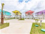 A row of colorful rental cabins at BLUE WATER RV RESORT - thumbnail