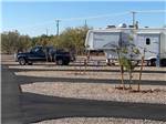 Black truck parked in front of a fifth wheel in a back in site at CASINO DEL SOL RV PARK - thumbnail