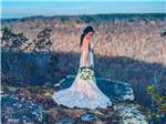 A lady in a wedding dress standing atop a mountain at BIGFOOT ADVENTURE RV PARK & CAMPGROUND - thumbnail