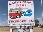 Couple standing in front of sign announcing Blaze-In-Saddle RV Park at BLAZE-IN-SADDLE RV PARK - thumbnail