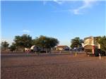 A row of gravel sites with benches at BLAZE-IN-SADDLE RV PARK - thumbnail