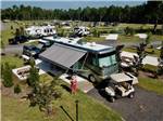 Camper and golf cart in campsite at MADISON RV & GOLF RESORT - thumbnail