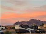A motorhome parked in a site at sunset at CAMPGROUND USA RV RESORT - thumbnail