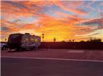 A travel trailer parked under the sunset skies at CAMPGROUND USA RV RESORT - thumbnail