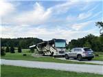 Gravel RV space with motorhome and SUV at PINE CREEK CABINS AND CAMPGROUND - thumbnail