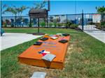 An outdoor area set up for a game of corn hole at REEL CHILL RV RESORT - thumbnail