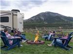 A group of people sitting around a fire pit at ALPINE VALLEY RV RESORT - thumbnail