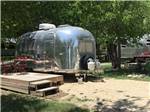 Small Airstream in a sandy campsite at OFF THE VINE RV PARK - thumbnail