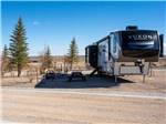 A fifth wheel trailer parked in a dirt site at LITTLE AMERICA RV PARK - thumbnail