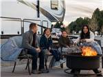 A family roasting marshmallows next to their RV at LITTLE AMERICA RV PARK - thumbnail