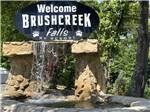 A welcome sign with a waterfall at BRUSHCREEK FALLS RV RESORT - thumbnail