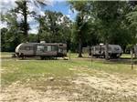 Two travel trailers parked on grassy sites at CHICKASAWHAY RIVER RV PARK - thumbnail