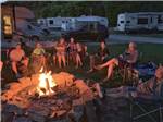 A group of people sitting around a fire pit at DENTON FERRY RV PARK & CABIN RENTAL - thumbnail